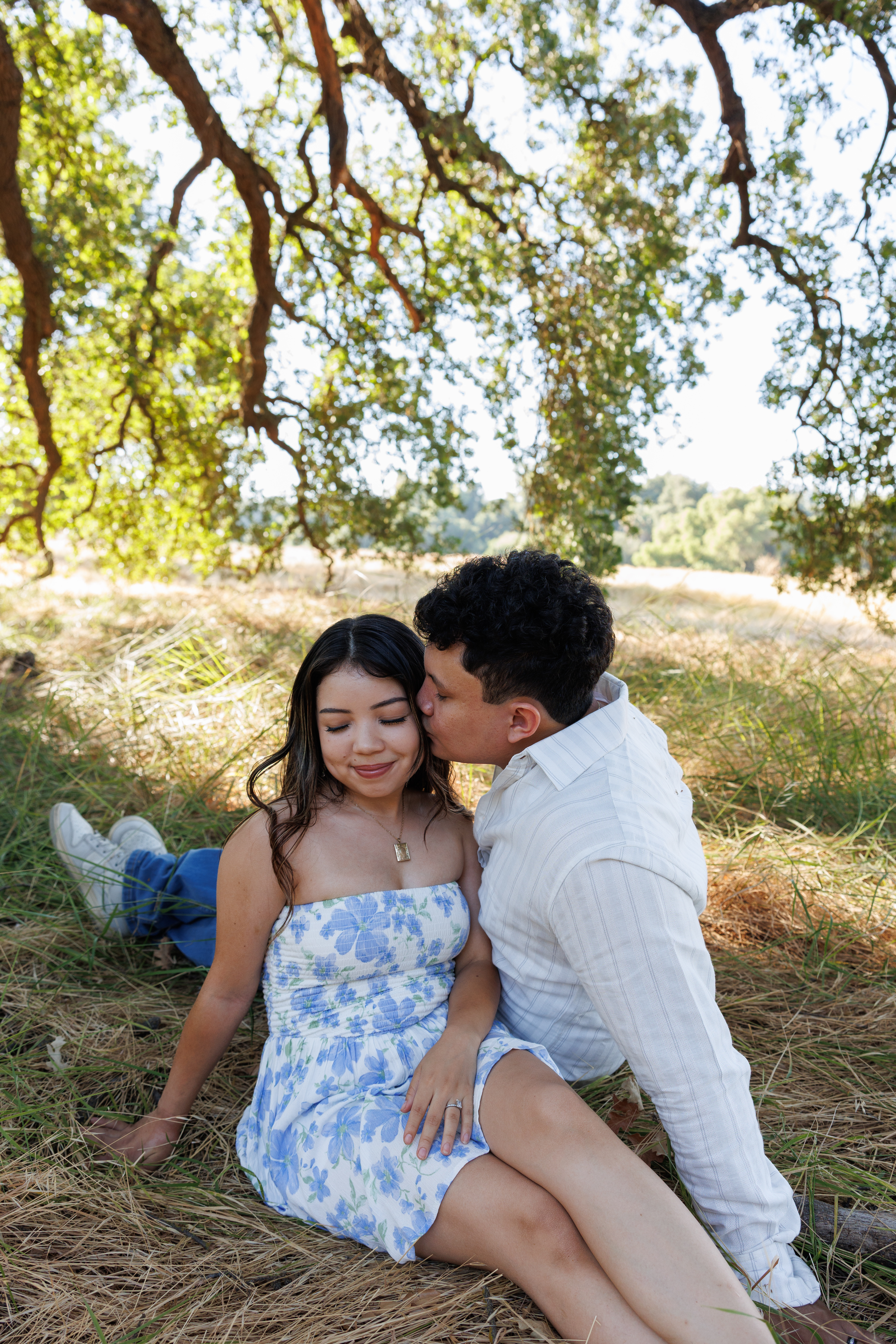 Couple relaxing under oak tree in summer